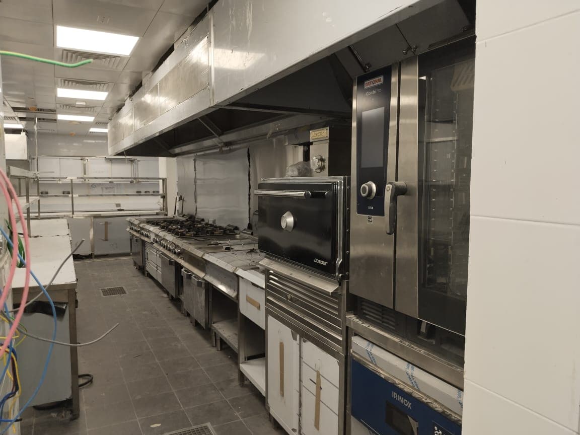 Commercial cooking line with gas ranges, Josper charcoal oven, Rational combi oven and Irinox blast chiller under stainless extract canopies, Dubai